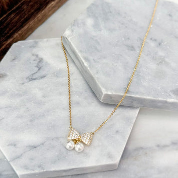 Bow with hanging pearl necklace
