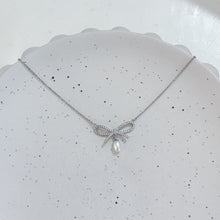 Sliver bow with hanging pearl necklace