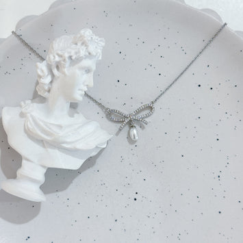 Sliver bow with hanging pearl necklace