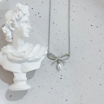 Sliver bow with hanging pearl necklace
