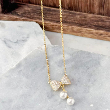 Bow with hanging pearl necklace
