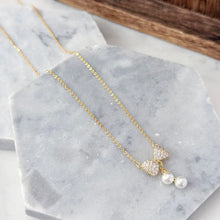 Bow with hanging pearl necklace