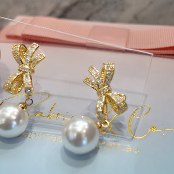 Bow with hanging pearl earrings