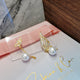 Wings with hanging pearl earrings