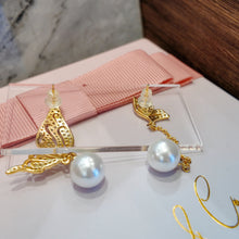 Wings with hanging pearl earrings